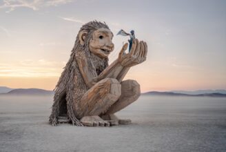 Rose Wonders, a wooden troll holding a human adult in it's hands.