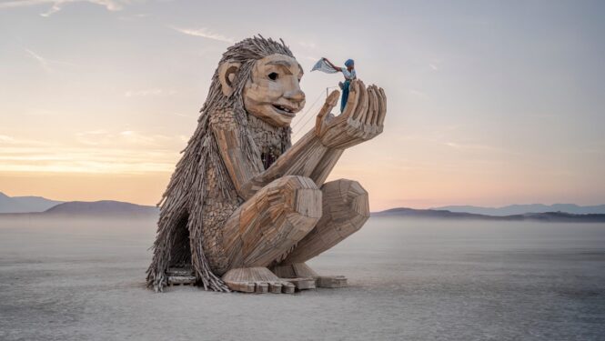 Rose Wonders, a wooden troll holding a human adult in it's hands.