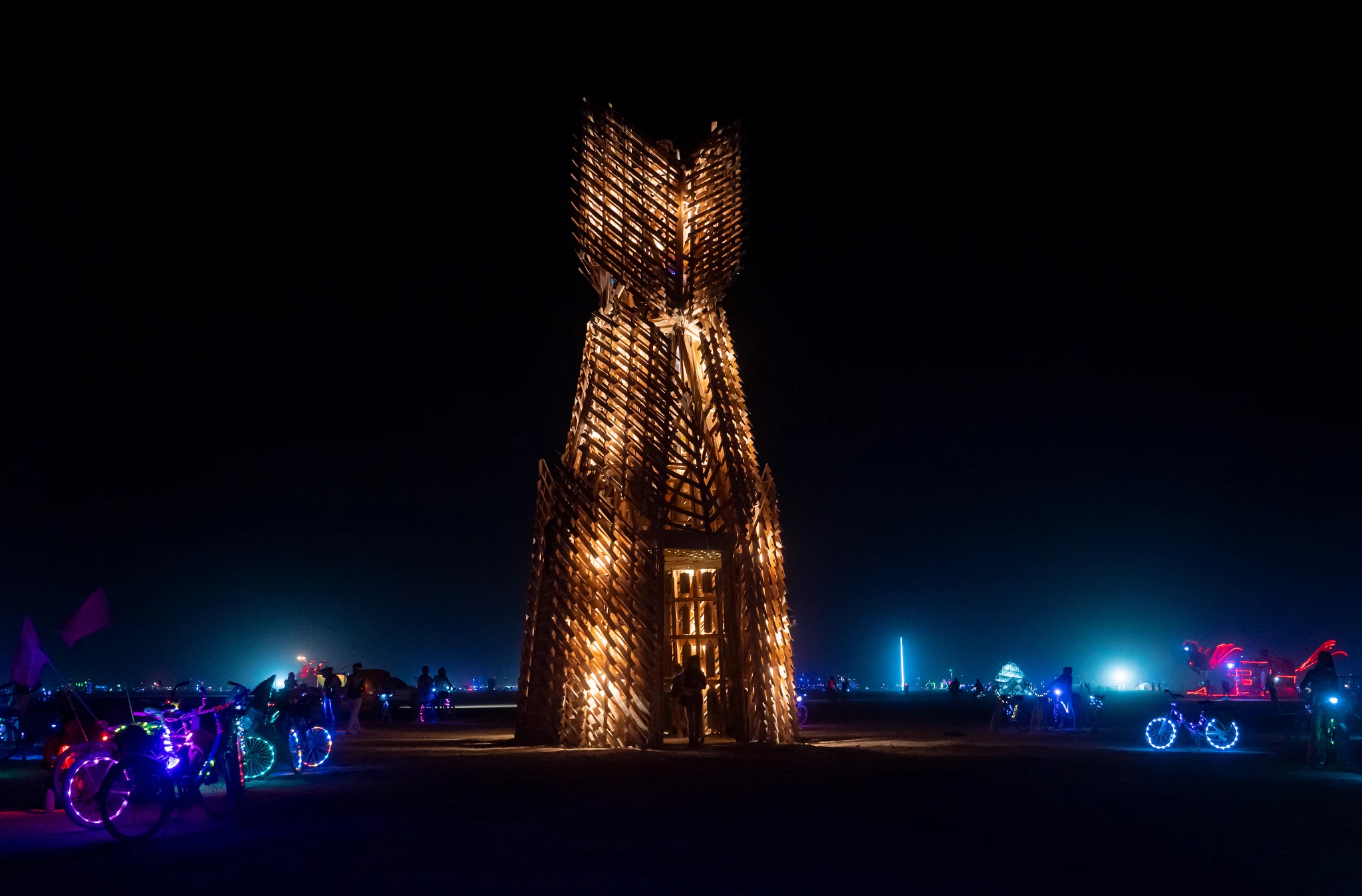 A tall wooden cat radiating light from the inside through elaborate cut-outs.